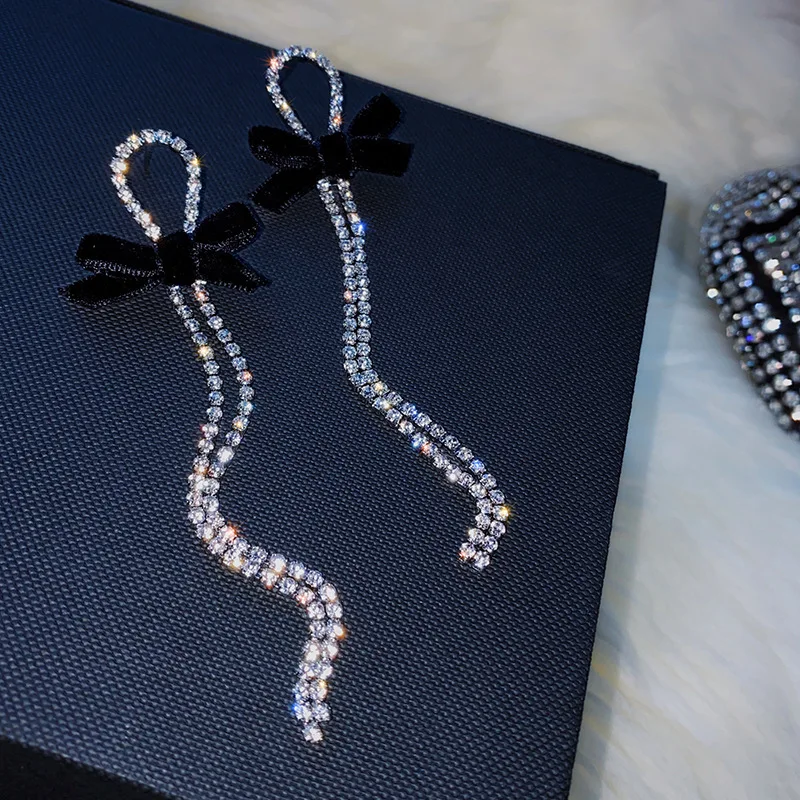 עגילים ארוכים נוצצים עם פפיון שחור ועיצוב אלגנטי – תמונה 2